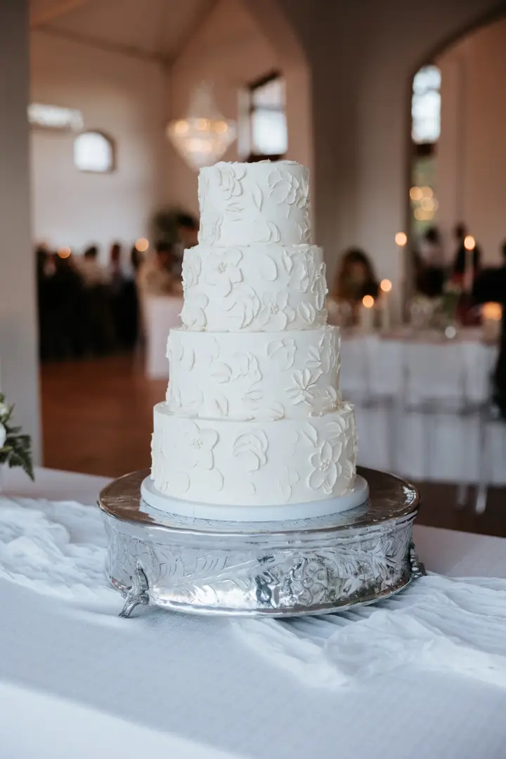 A four-tier off-white wedding cake with floral buttercream flowers - by Crumb Boutique Bakery, Cape Town